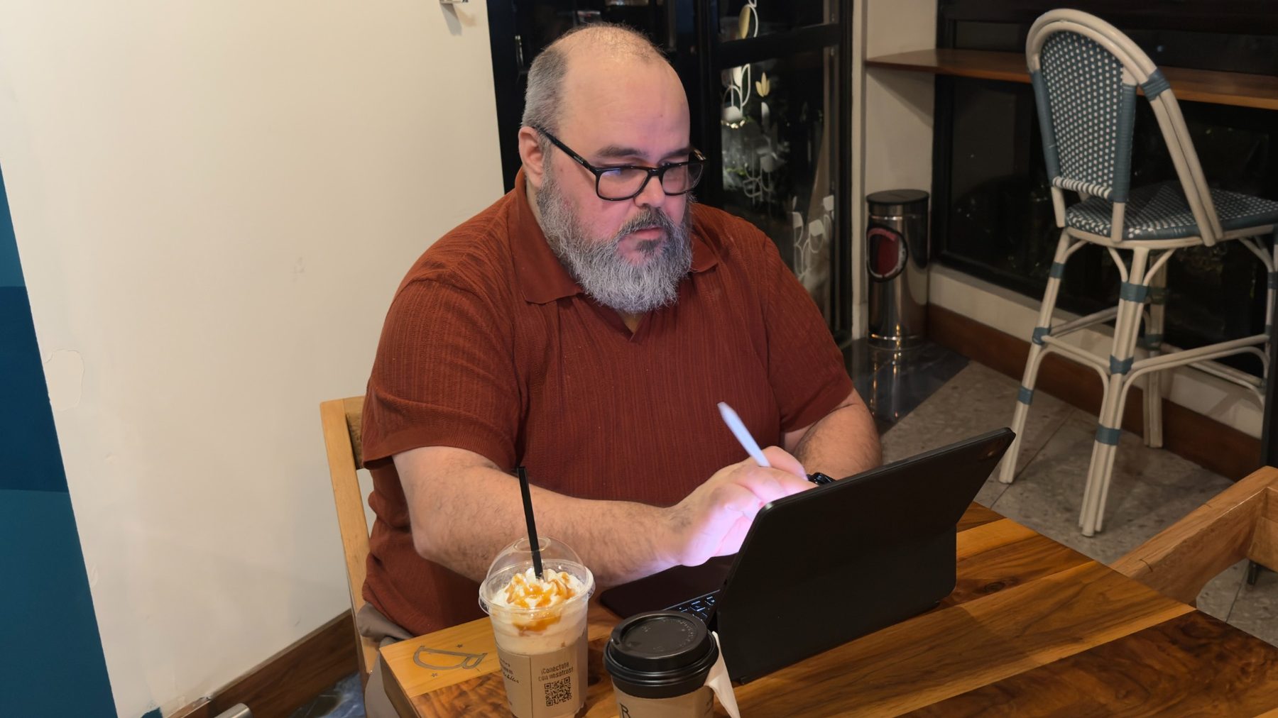 Jason Rosenburg writing with an iPad in a coffee shop